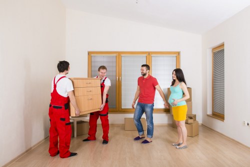 Professional movers carrying furniture through a central London apartment building